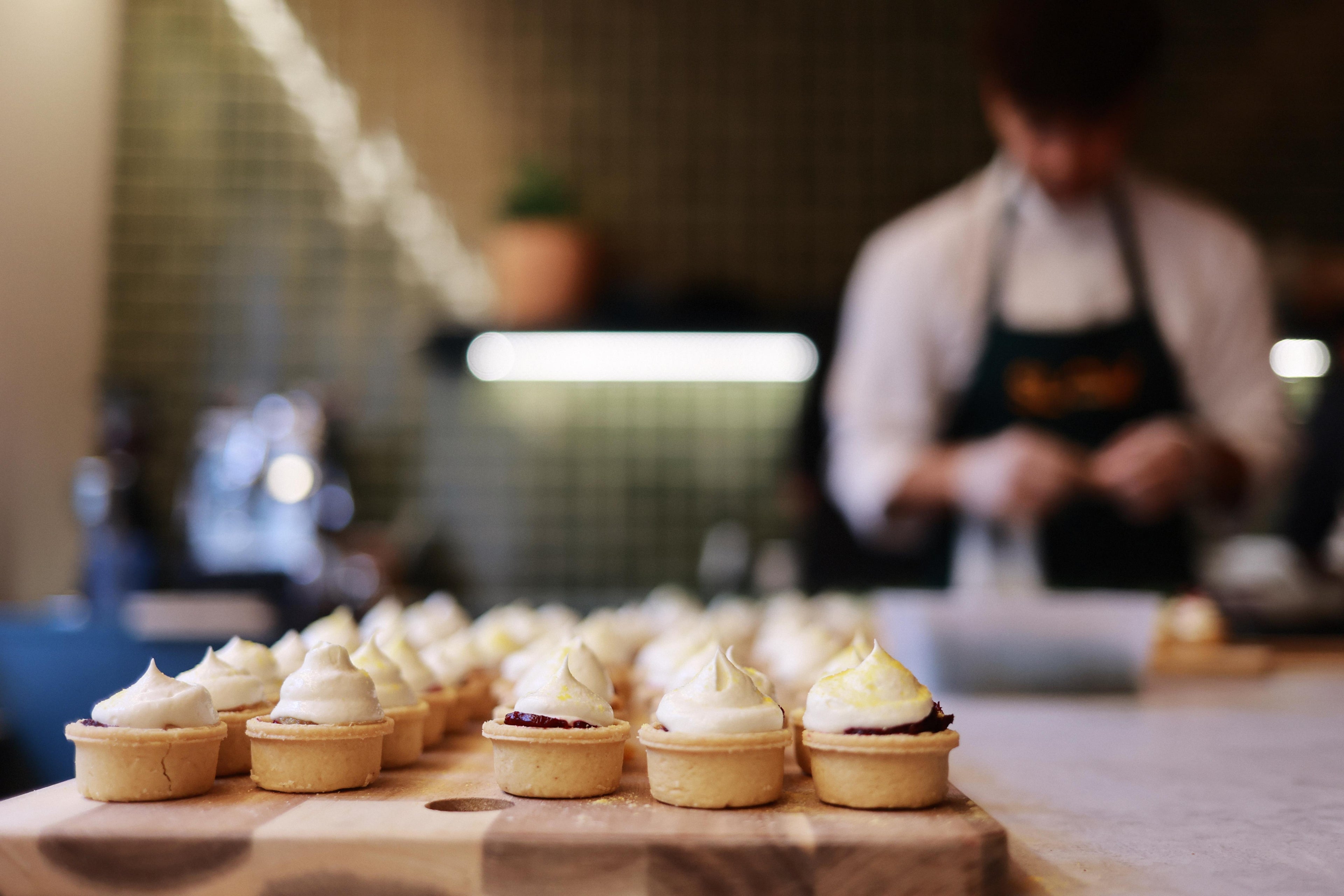 Serious of canapes with chef blurred in background. Confit beetroot, smoked labne tartlets.