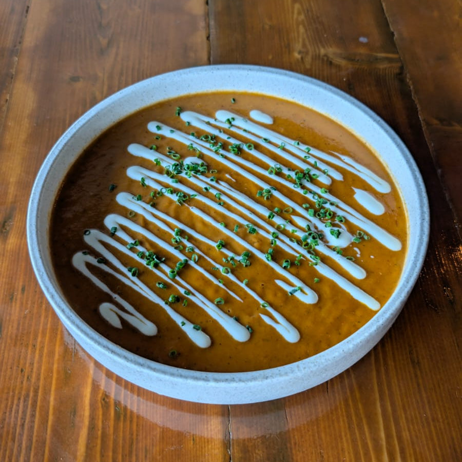 Serving of summer tomato bisque on a wooden table