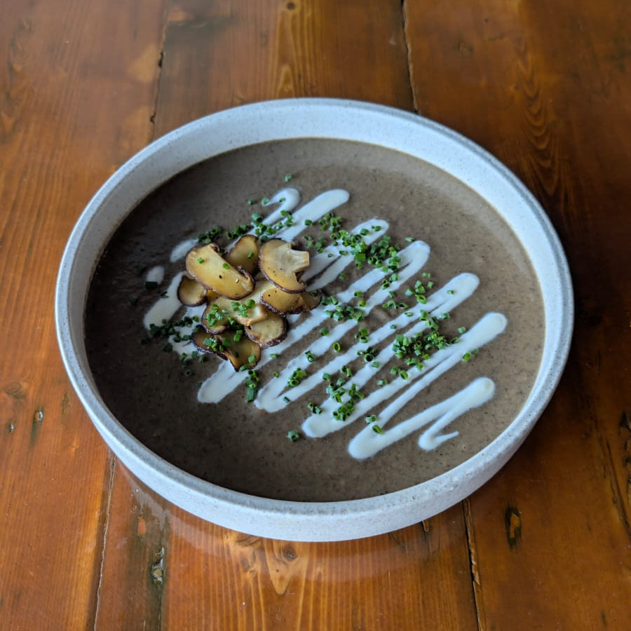 Bowl of soup with garnishes on a wooden table