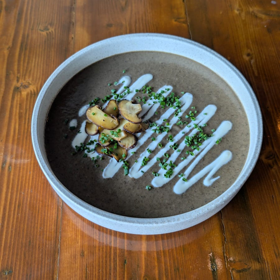 Mushroom bisque with cream & truffle garnished on a wooden table